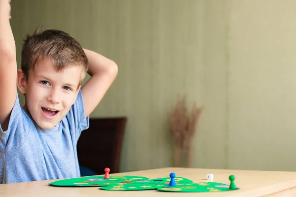 Criança feliz goza de vitória no jogo de tabuleiro de Natal — Fotografia de Stock
