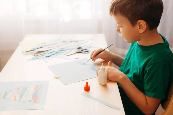 Little Boy Making kerstkaart zittend aan tafel — Stockfoto