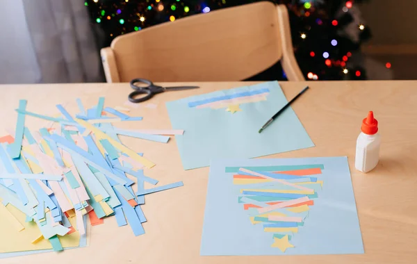 Creating Christmas card. Colored paper, glue, example of ready-made card — Stock Photo, Image