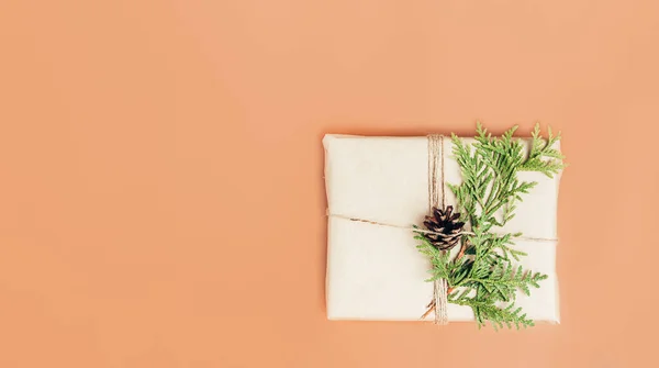 Caja de regalo envuelta en papel artesanal y decorada con rama de ciprés verde —  Fotos de Stock