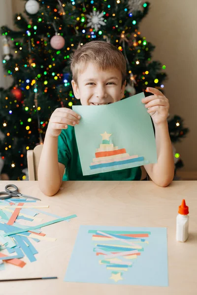 Little Boy Making kerstkaart zittend aan tafel — Stockfoto