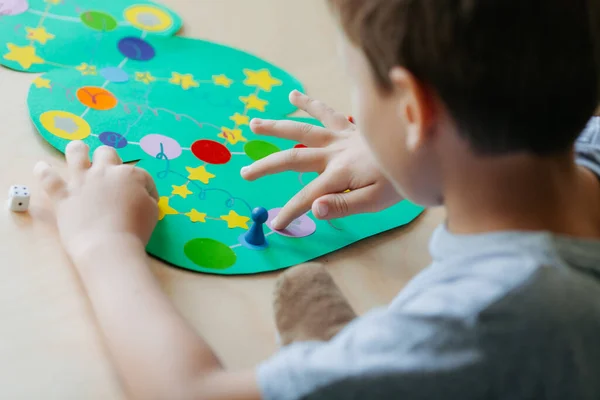 Enfant lance les dés et déplace la puce sur le terrain de jeu de Noël — Photo