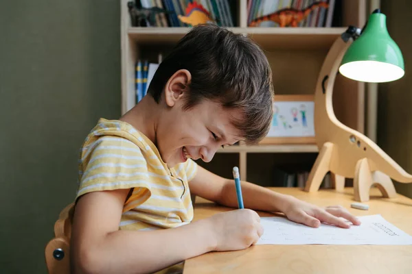 子供部屋の机に座って数学のレッスンをしている少年 — ストック写真