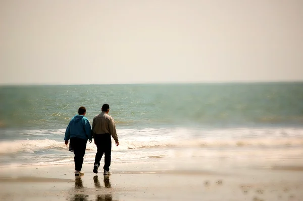 それ以上の年齢のカップル、ビーチの上を歩いて — ストック写真