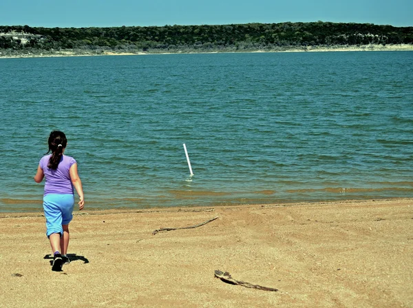 Girl strides toward water — Stock Photo, Image