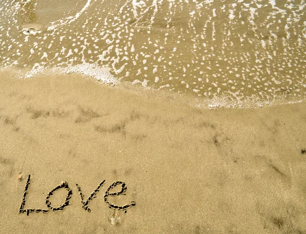 Love written in the sand with wave 13-1 — Stock Photo, Image