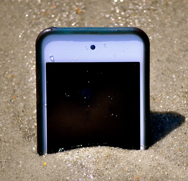 Smartfon w piasku podobny do iPhone 'a — Zdjęcie stockowe