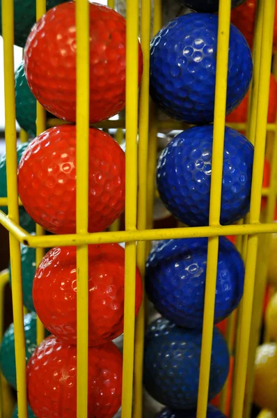 Piłki golfowe czerwony i niebieski w klatce żółty — Zdjęcie stockowe