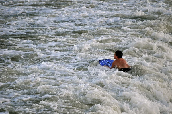 Çocuk surfs dalgalar halinde — Stok fotoğraf