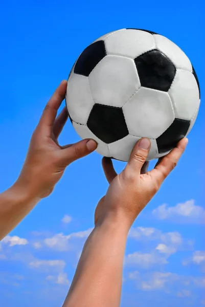 Futebol, bola de futebol na mão do homem no céu azul — Fotografia de Stock