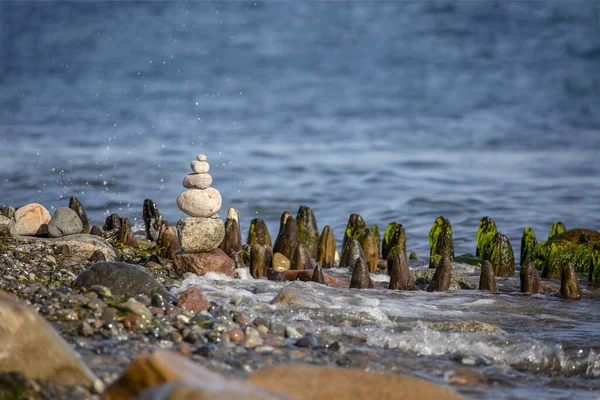 Nature Art stone cairn with round pebble and water, created on baltic sea beach, perfect for a greeting card, gift bag or calendar image