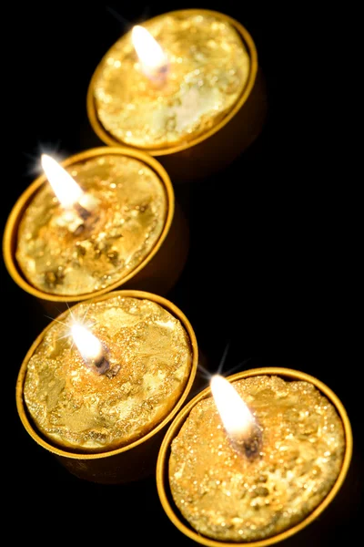 Golden candles on a black background. — Stock Photo, Image