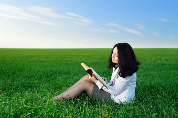 Девушка в деловом костюме читает книгу — стоковое фото