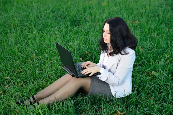 Una donna in giacca e cravatta con un portatile — Foto Stock