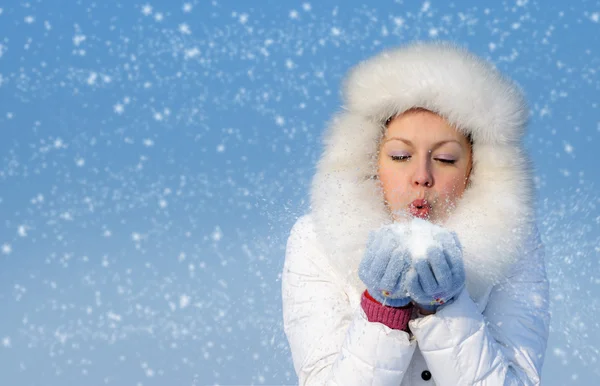 Girl blows off snowflakes from the hand — Stock Photo, Image