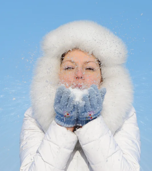 Meisje blaast uit sneeuwvlokken uit de hand — Stockfoto
