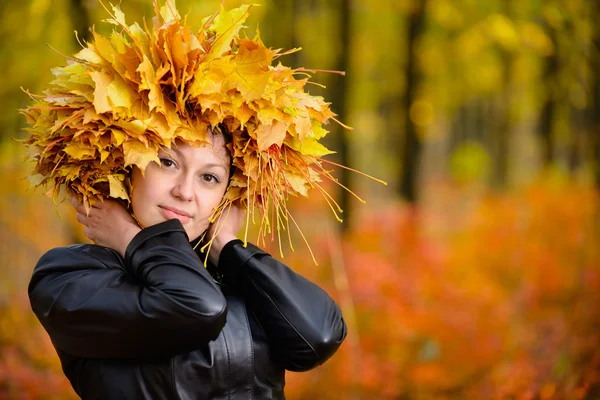 Mooie vrouw in de kroon van de herfst bladeren — Stockfoto