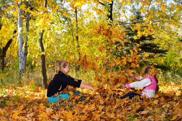 Children play yellowing of autumn leaves — Stock Photo, Image