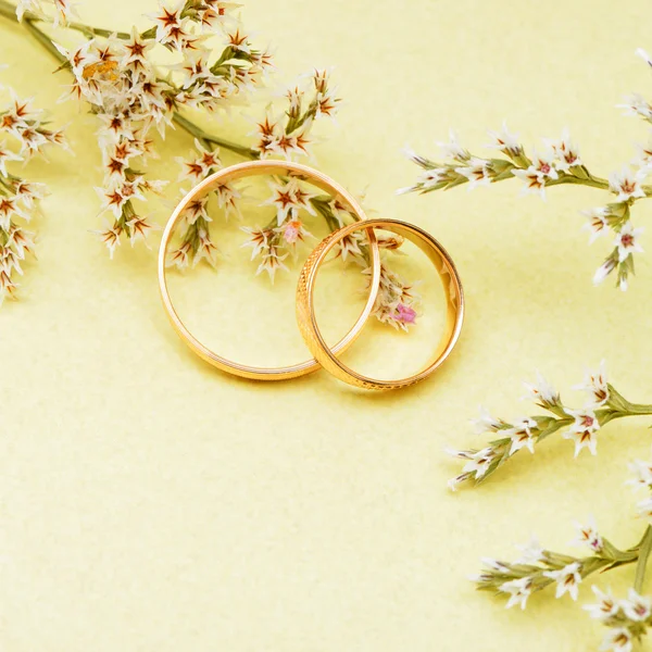 Anéis de casamento de ouro e flores ramo — Fotografia de Stock