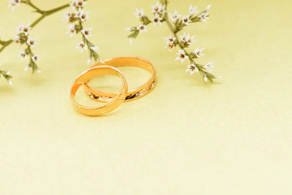 Gold wedding rings and branch flowers — Stock Photo, Image