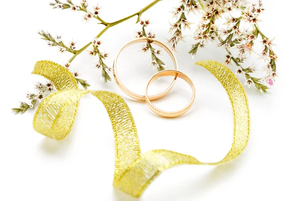 Gold wedding rings and branch flowers — Stock Photo, Image