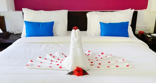 与一只孔雀的毛巾放在床上从酒店房间 — 图库照片