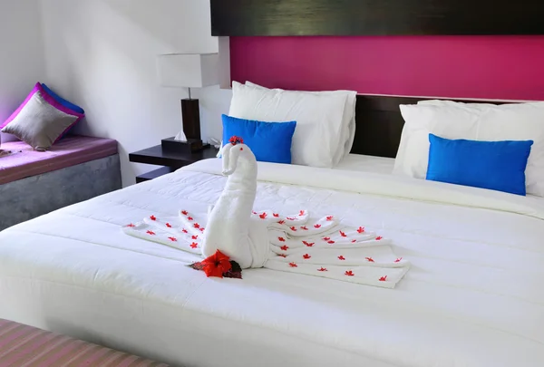与一只孔雀的毛巾放在床上从酒店房间 — 图库照片
