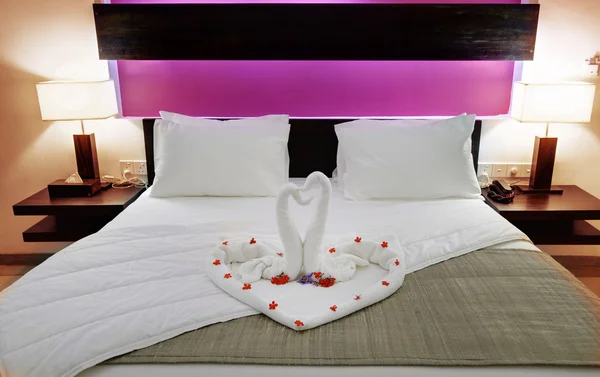 Room in a hotel with swans from the towel on the newlyweds bed — Stock Photo, Image