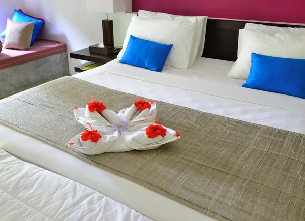 在一家酒店的毛巾和 th 上的花朵装饰房间 — 图库照片