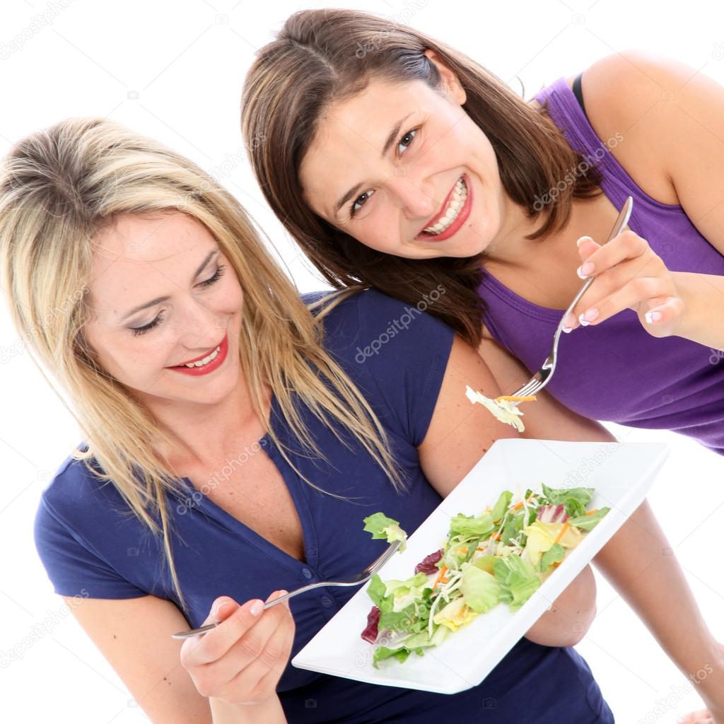 Female friends sharing a plate of salad Female friends sharing a plate of s
