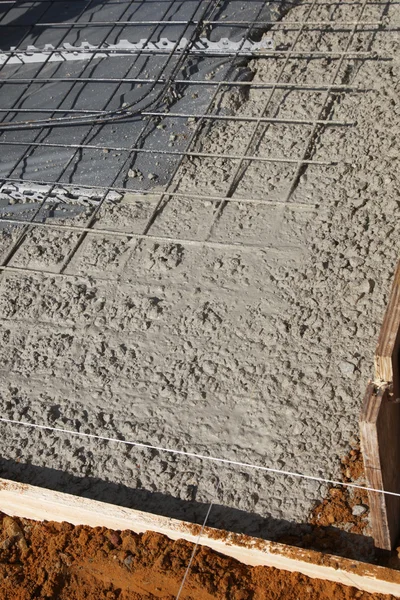 Steel reinforcing mesh with freshly poured concrete slab — Stock Photo
