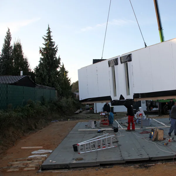 Grúa entregando una casa de madera prefabricada Grúa entregando una prefábrica — Foto de Stock