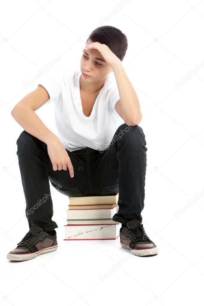 Teenage boy sitting on books waiting