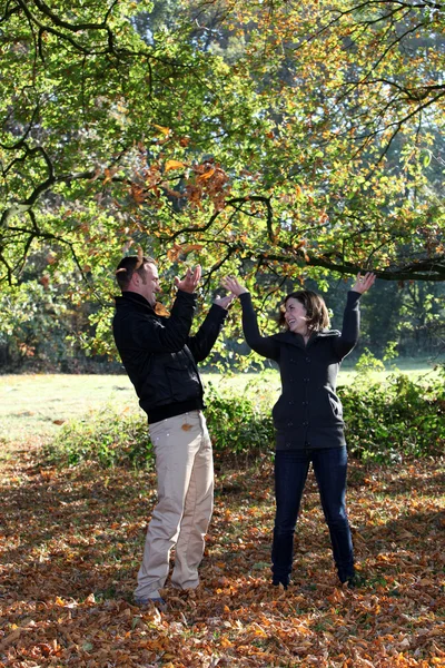 Ungt par njuter av hösten skogen — Stockfoto