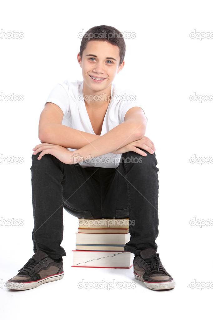 Teenager sitting on pile of books