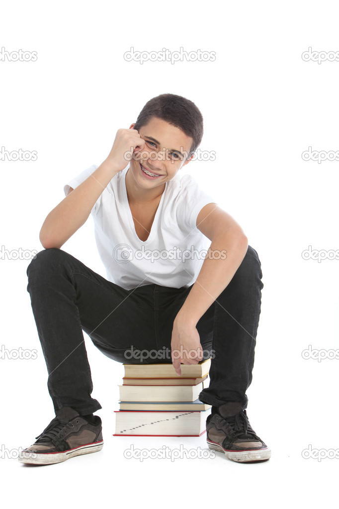 Happy teenage student sitting on his books