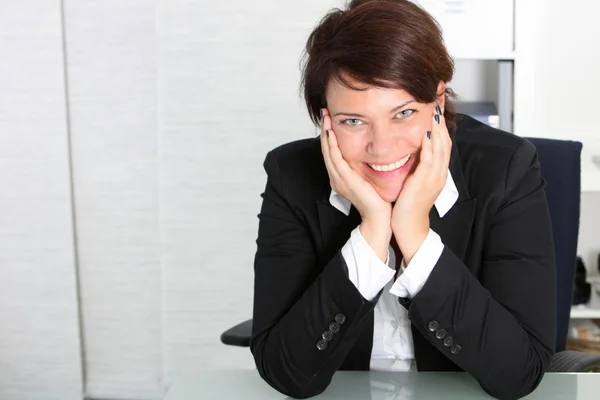 Sonriente profesional de negocios en su escritorio Sonriente profesional de negocios en su escritorio — Foto de Stock