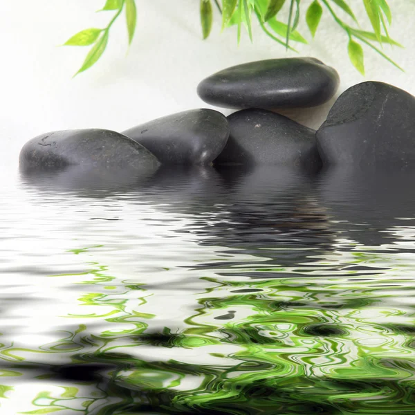 Black basalt spa stones in water — Stock Photo, Image