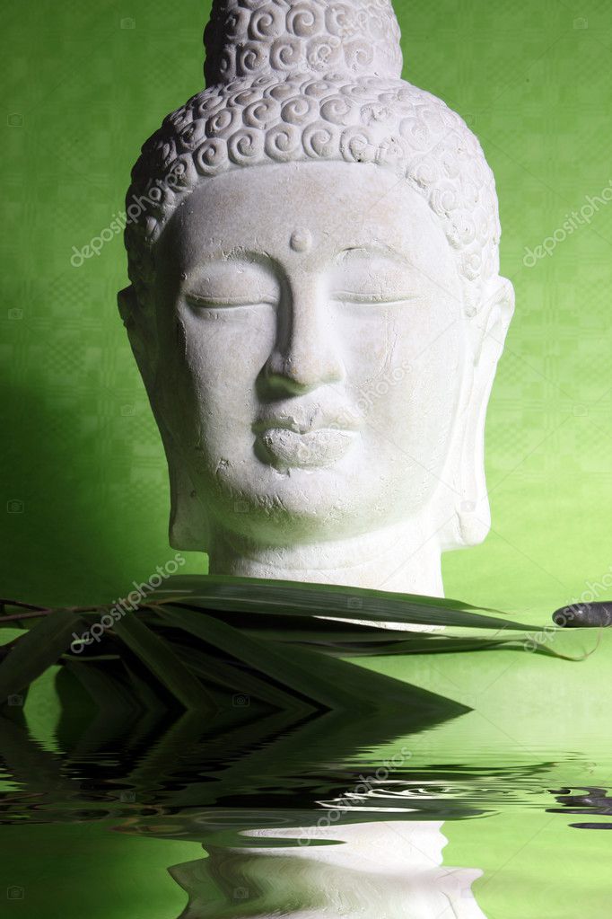 Head of a yoga statue on green background