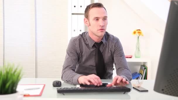 Empresario escribiendo en un teclado y hablando por teléfono — Vídeos de Stock