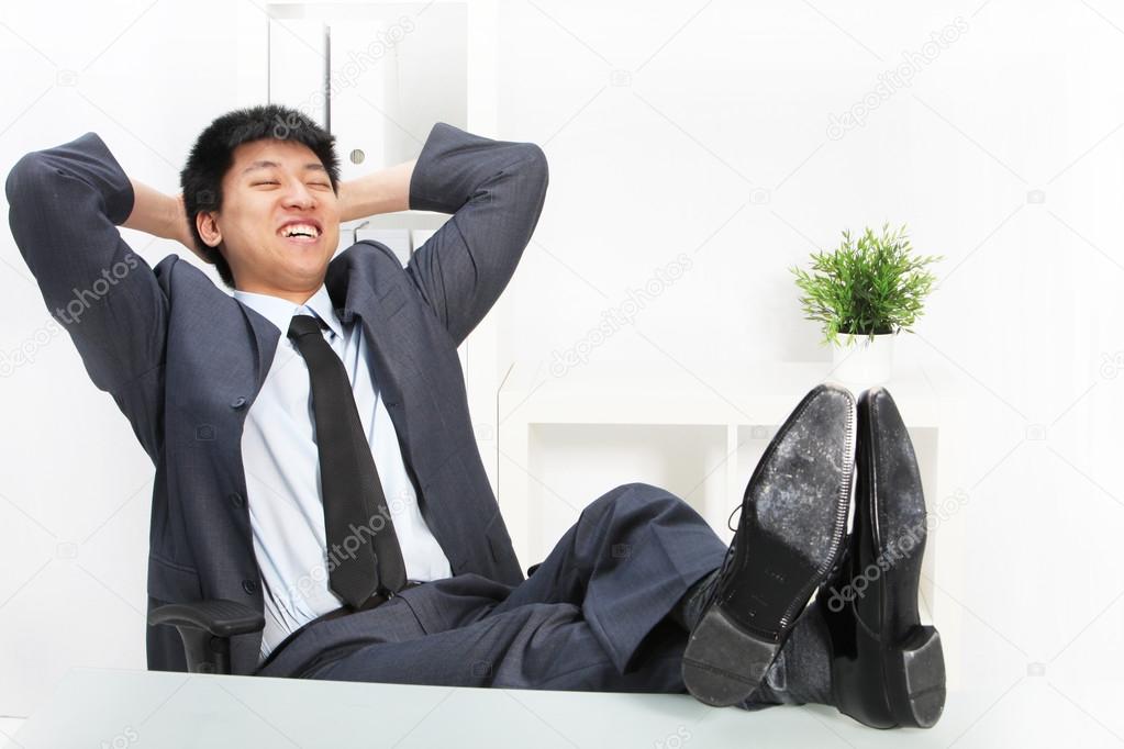 Asian businessman relaxing with his feet up