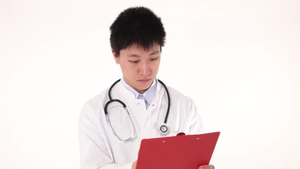 Giovane asiatico medico writing su suo clipboard — Video Stock