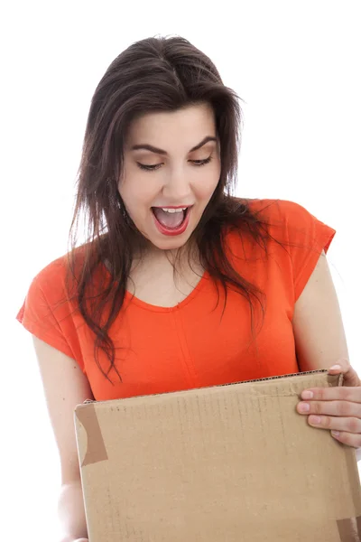 Surprised young woman holding a cardboard box — Stock Photo, Image