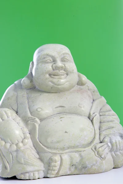 Buda heykelcik yeşil bir arka plana dayanır — Stok fotoğraf