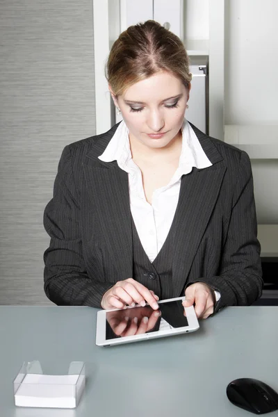 Bir tablet üzerinde çalışan iş kadını — Stok fotoğraf