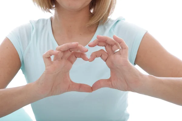 Mujer haciendo un gesto de corazón con los dedos — Foto de Stock