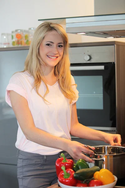 Mooie blonde vrouw een maaltijd bereiden — Stockfoto
