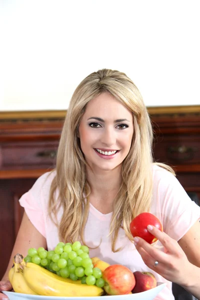 Lächelnde junge Frau mit einer Schale voller Früchte — Stockfoto