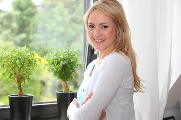 Beautiful woman in front of a view window — Stock Photo, Image