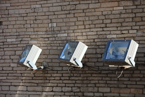 Три прожектори на цегляній стіні — стокове фото